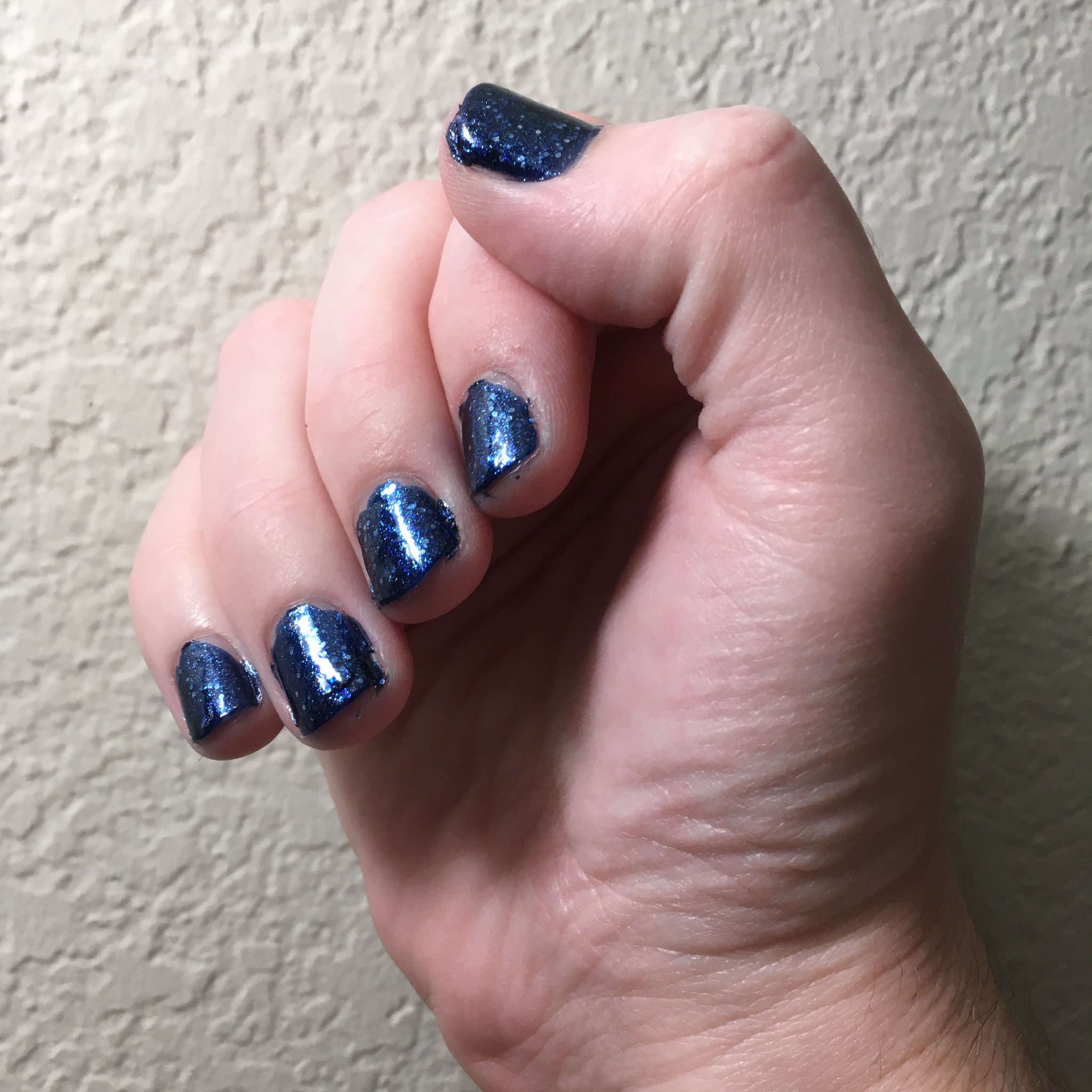 Essie #1659 “Once in a Blue Moon”, a dark blue polish with silver glitter.